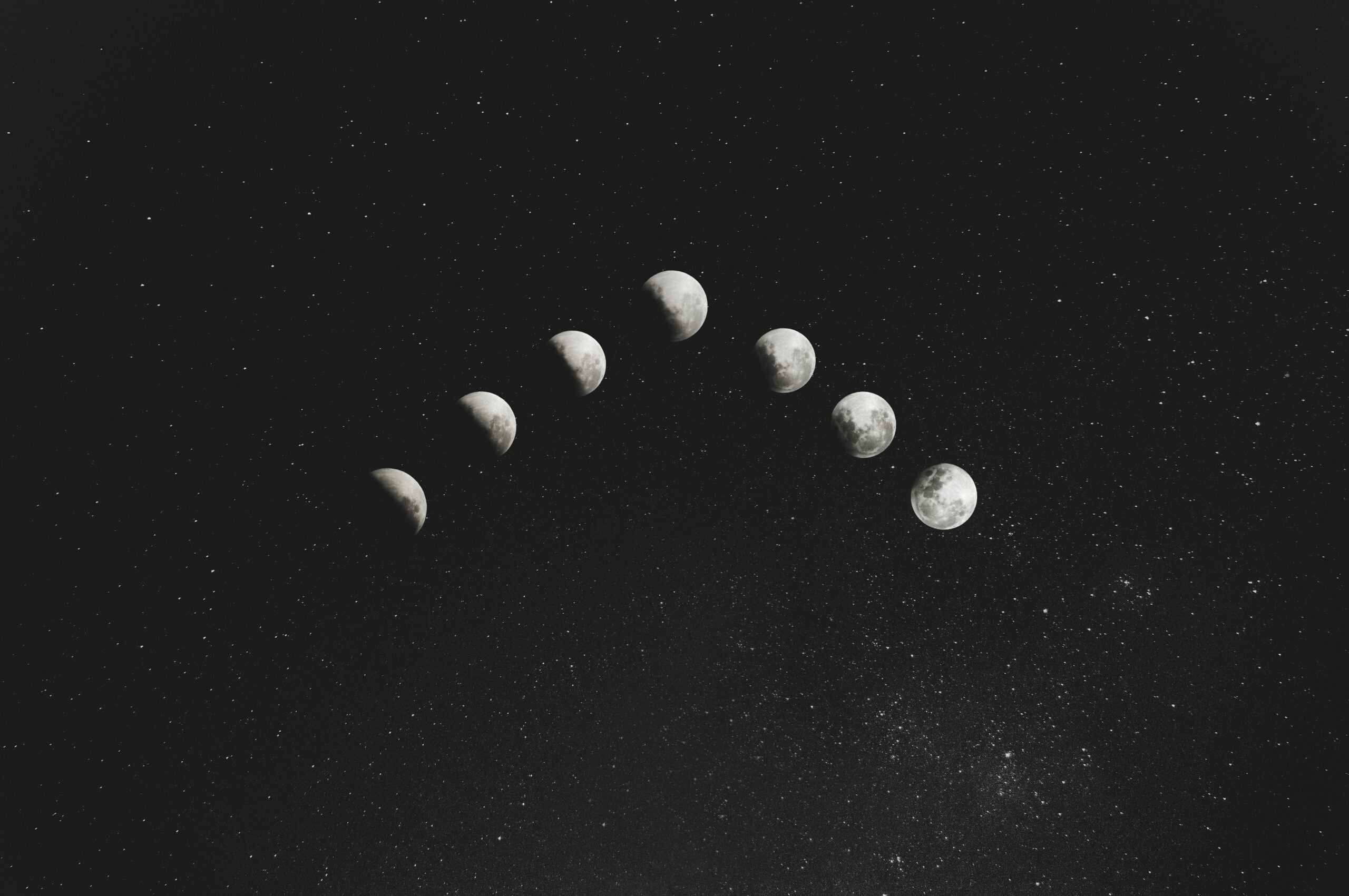 Sequence of moon phases arcing across a starry night sky