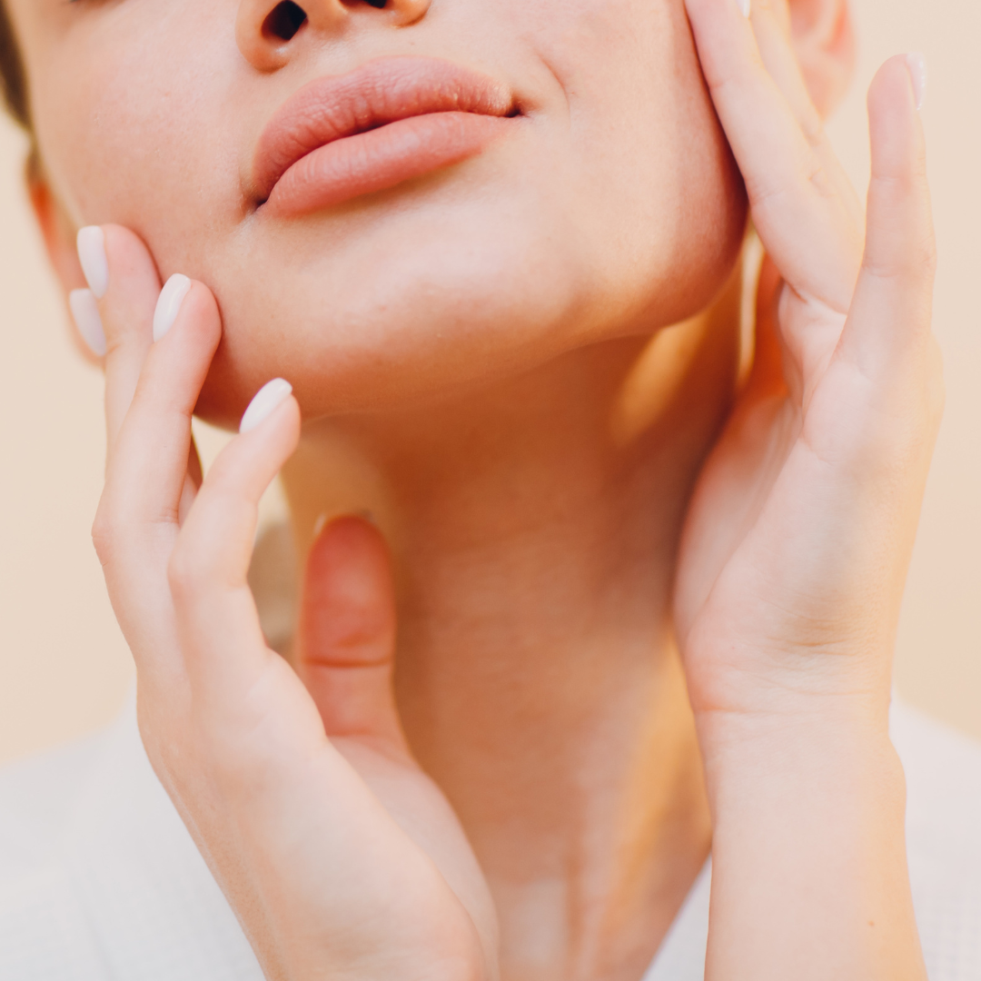 Close-up of a person touching their jaw and neck to illustrate morning facial puffiness