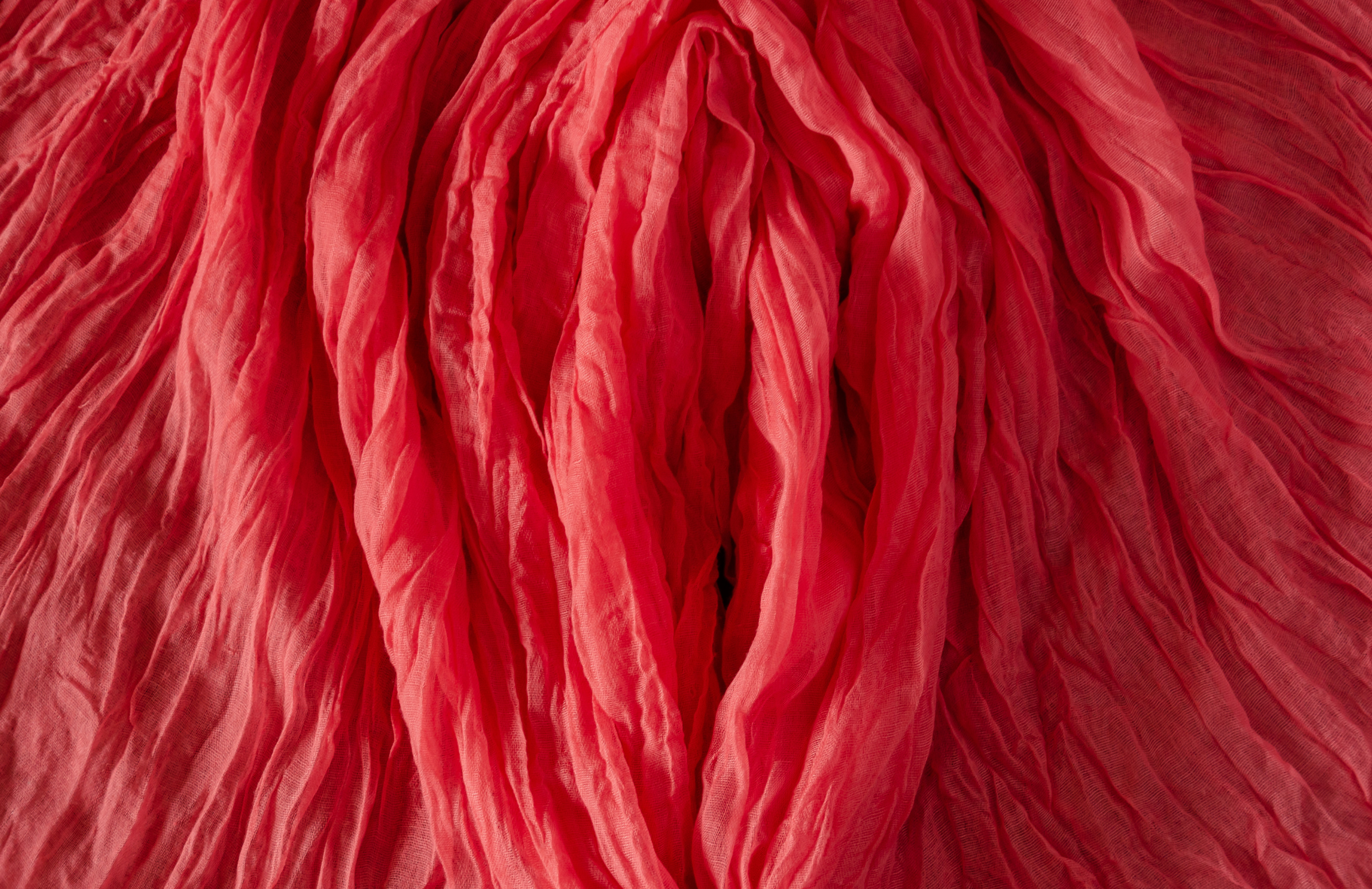 Red crinkled fabric arranged to suggest a vulva, symbolic header image for an article on bacterial vaginosis